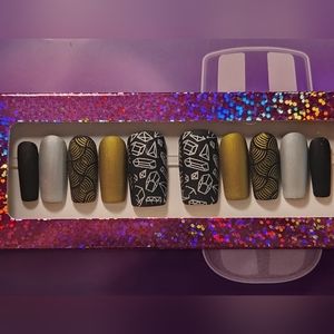Matte black with matte silver and matte gold designs. Press On Nails